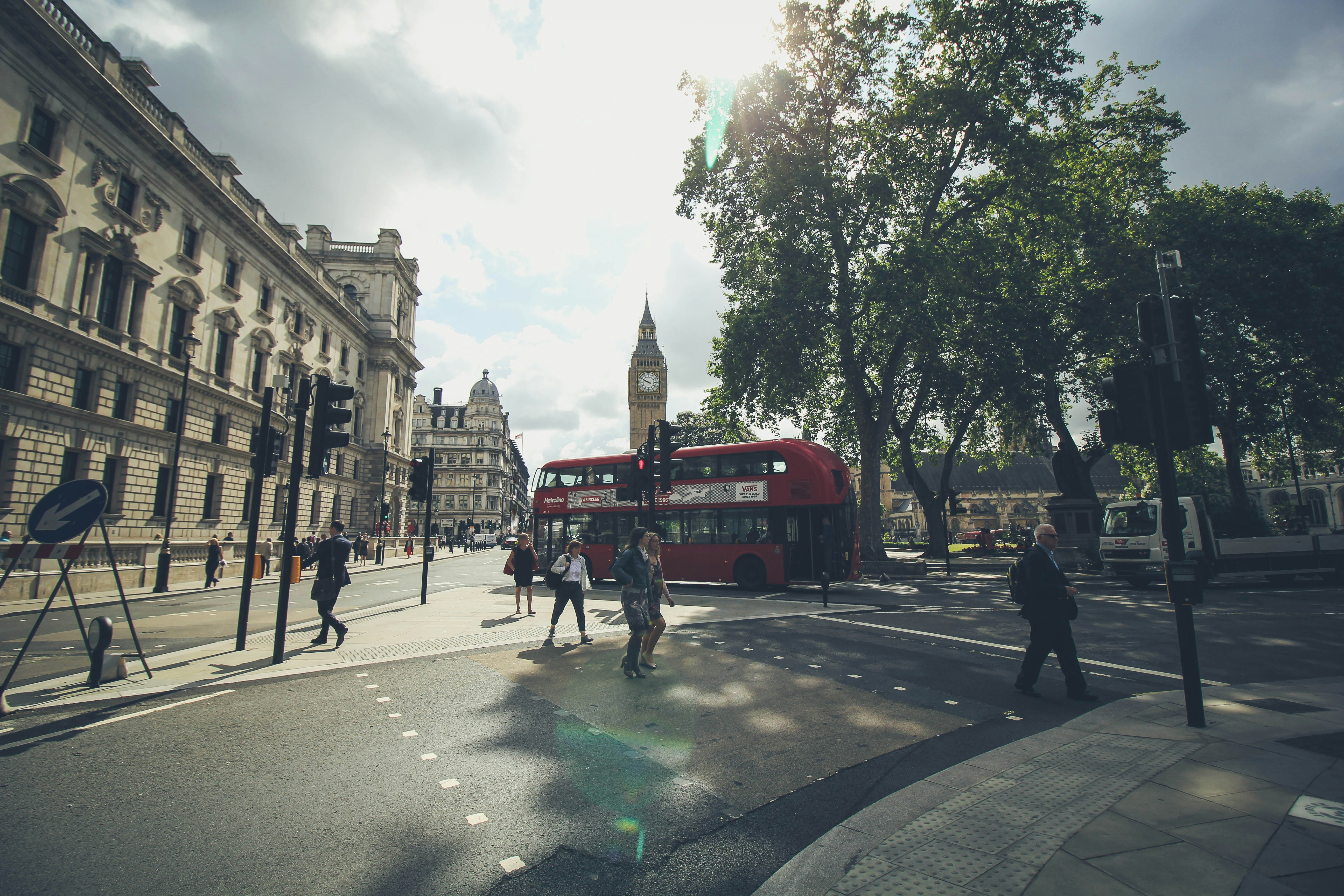 group of people walking on London road beside double deaker bus